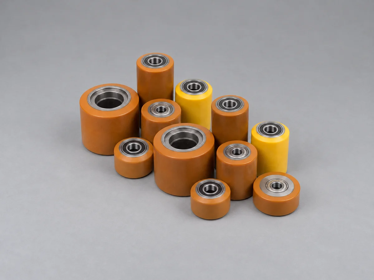 A group of orange-brown and yellow coated cylindrical parts with metal inner bores